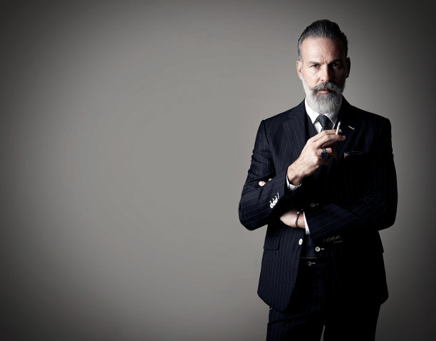 吸烟商人的肖像穿着时髦的西装，站在对面图片下载