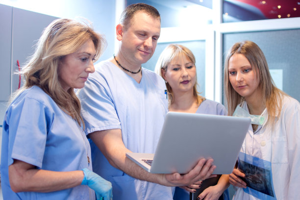 医护人员在医院检查笔记本电脑上的医疗报告。图片下载