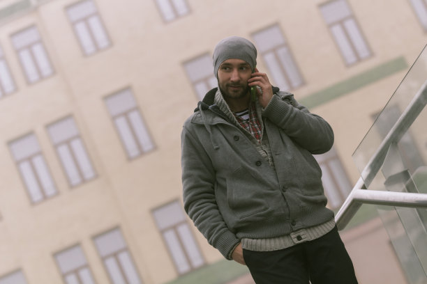 年轻的潮男在户外使用手机。图片下载