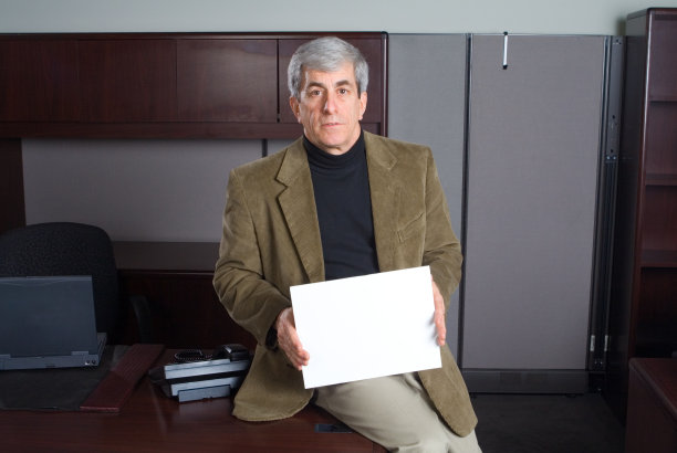 严肃的老商人在办公室拿着空白标牌图片下载