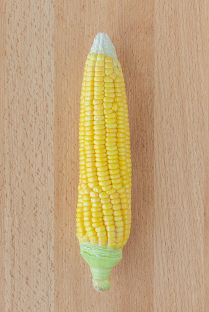 木桌背景上是新鲜的玉米芯和棕色的毛。图片下载