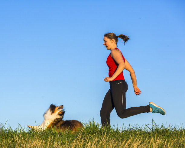 一个年轻女孩和一只狗在跑步图片下载