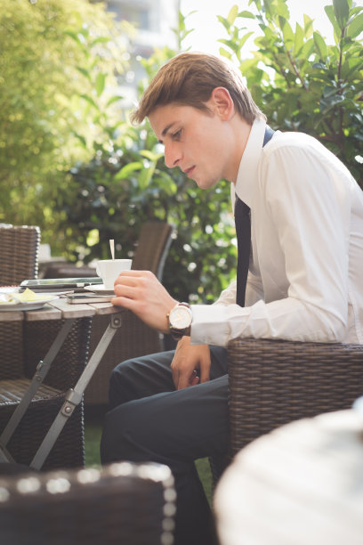 年轻英俊优雅的金发模特商人与TAB工作图片下载