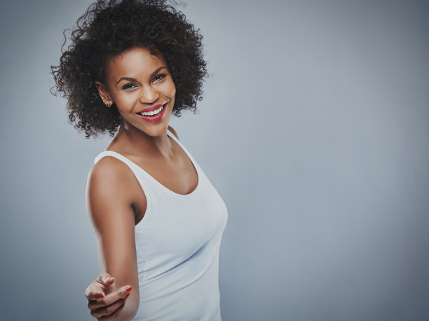 美丽快乐的女人在灰色的背景上跳舞图片下载