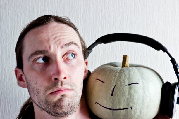 微笑的年轻人和带着耳机微笑的南瓜图片下载