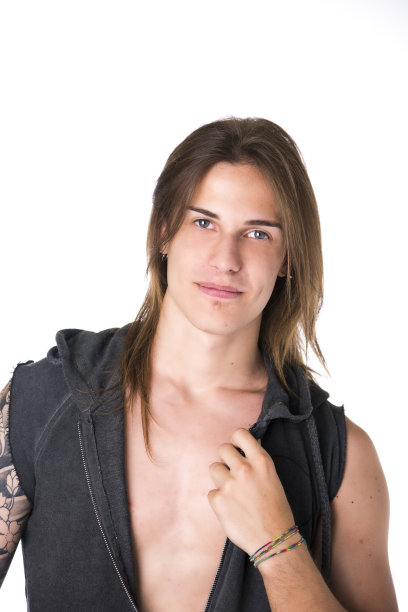 漂亮的年轻长头发男子在夹克摆姿势和微笑图片下载