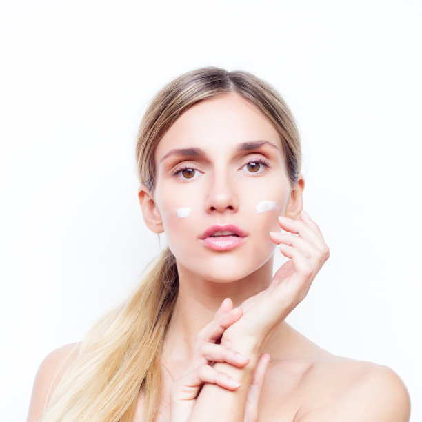 脸上涂着奶油的漂亮女人。美丽的概念。图片下载