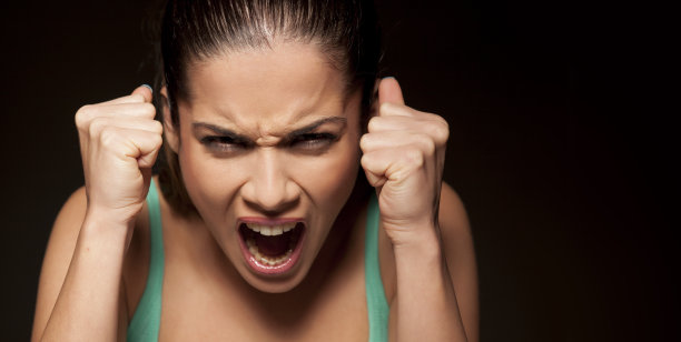 一个美丽愤怒的女孩在黑暗的背景上的肖像图片下载