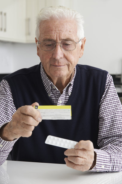 高级男子阅读药品包装信息图片下载