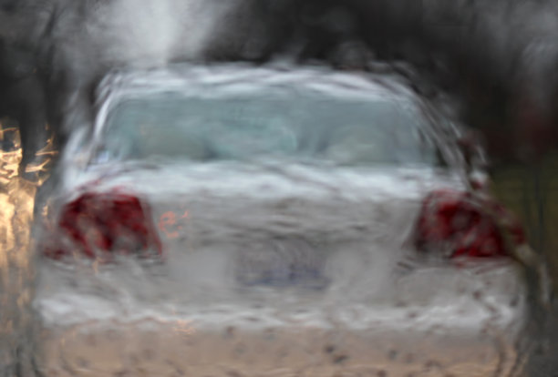 一辆白色汽车在大雨中行驶图片下载