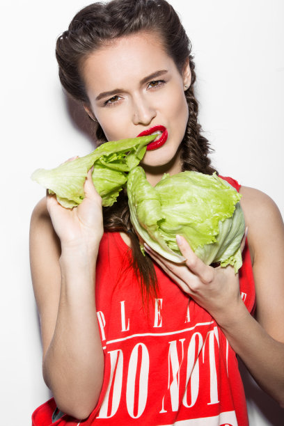 大胆有趣的女孩，梳着辫子，红唇，情绪化的吃东西图片下载