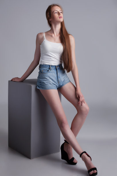 长腿模特坐在立方体上的工作室拍摄图片下载