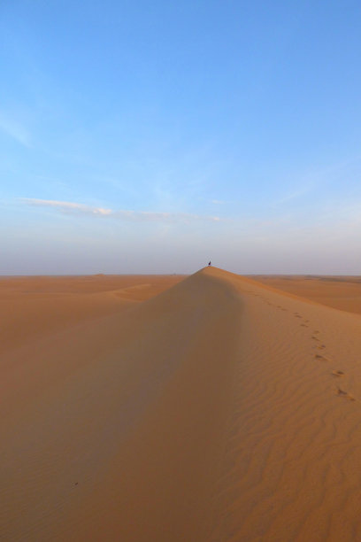 摄影师在沙漠中拍摄日落图片下载