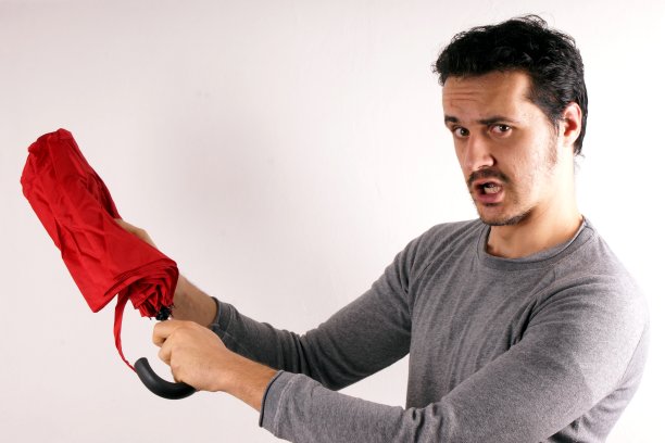 一个男人正在打开一把红色的伞图片下载