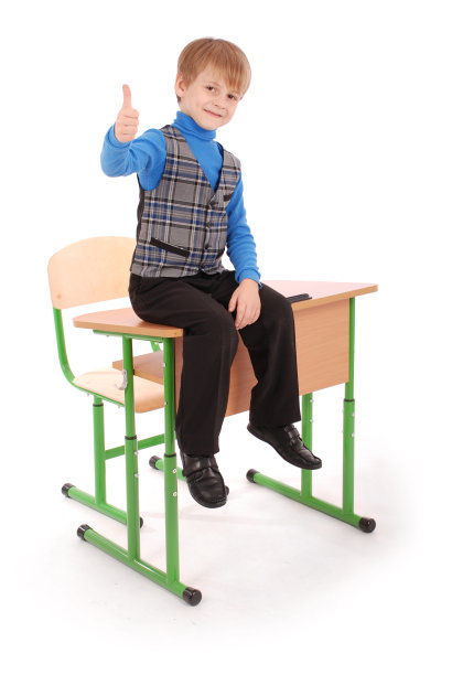 男孩的成功。男孩坐在课桌上图片下载