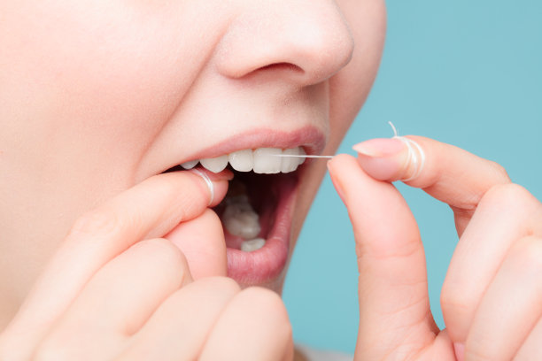 侧视图：使用牙线的微笑女人素材图片