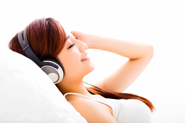 放松的年轻女子戴着耳机听音乐图片下载