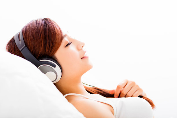 放松的年轻女子戴着耳机听音乐图片下载