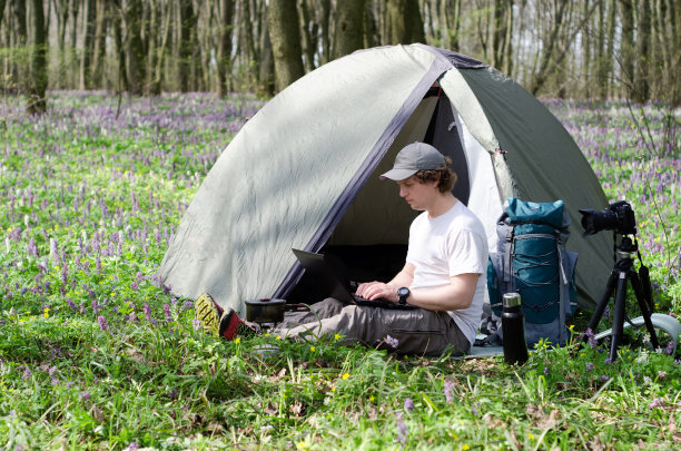 在户外帐篷营地工作的男摄影师。图片下载
