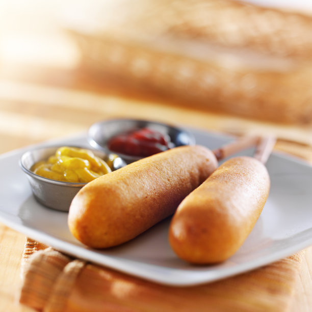 金色的玉米热狗在盘子里图片下载