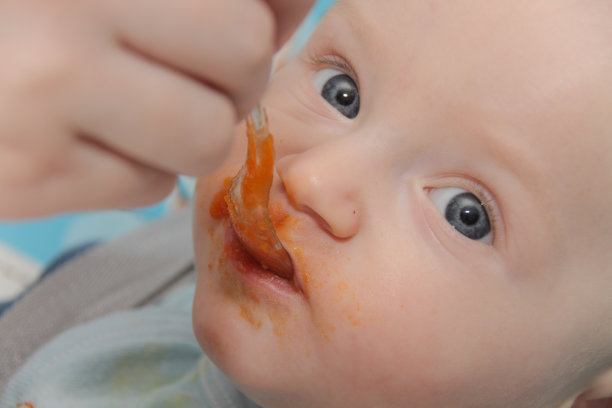 年轻的母亲在家里喂养儿子素材图片