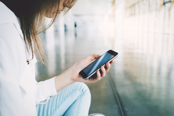 坐在地板上拿着手机的女孩图片下载