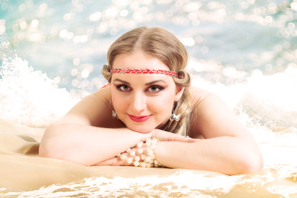 穿着夏装的年轻女子躺在沙滩上图片下载