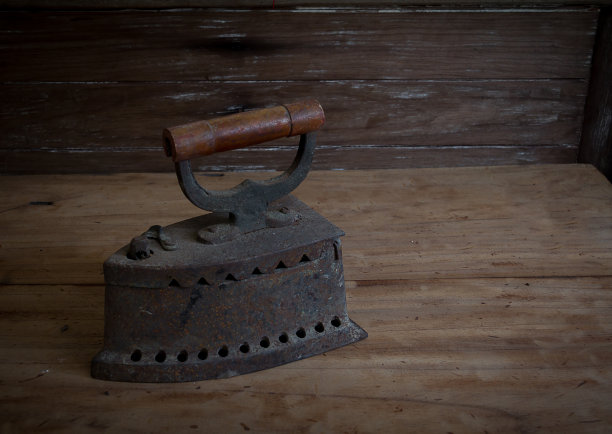 仿古熨斗，旧的煤熨斗放在旧的木地板上图片下载
