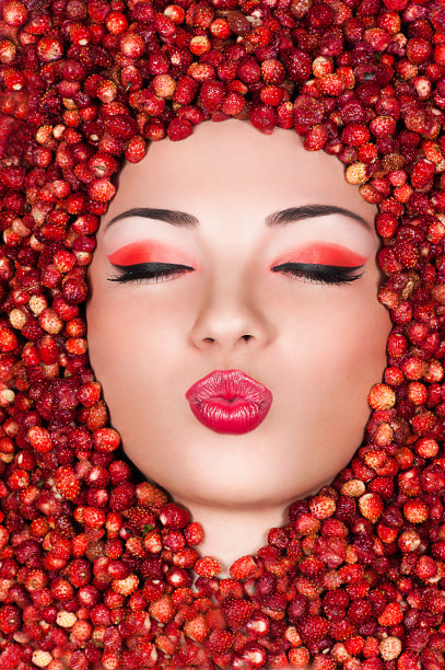 美丽的女人躺在野草莓上图片下载