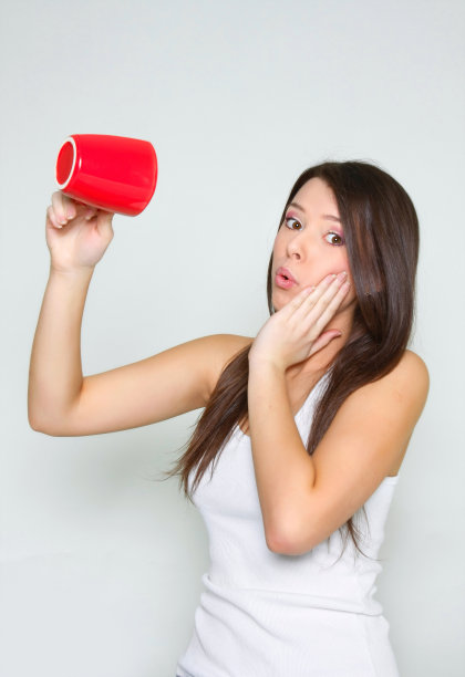 年轻姑娘拿着空茶杯图片下载