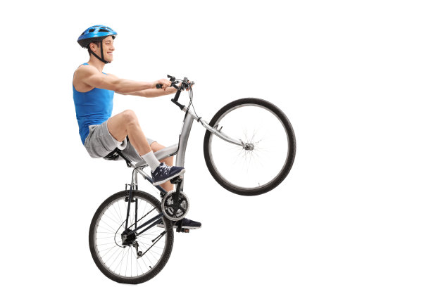 年轻的自行车手表演一个前轮特技图片下载