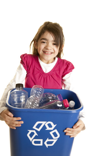 绿色环保:西班牙小女孩拿着装满垃圾的垃圾桶图片下载