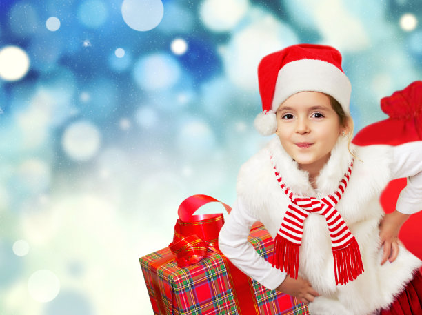带着礼物的圣诞小女孩。圣诞节的背景。图片下载