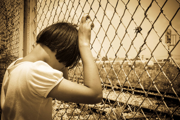 女孩伤心独自手握监狱，站在火车站图片下载