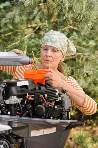 年长妇女往发动机里加油图片下载