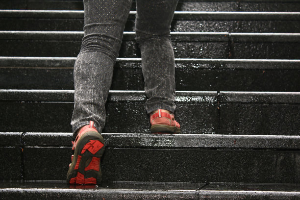 年轻女孩在爬水泥楼梯图片下载