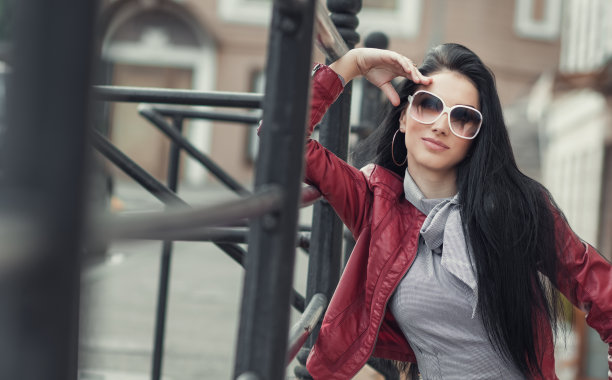 迷人的美丽的女人与太阳镜摆姿势。图片下载