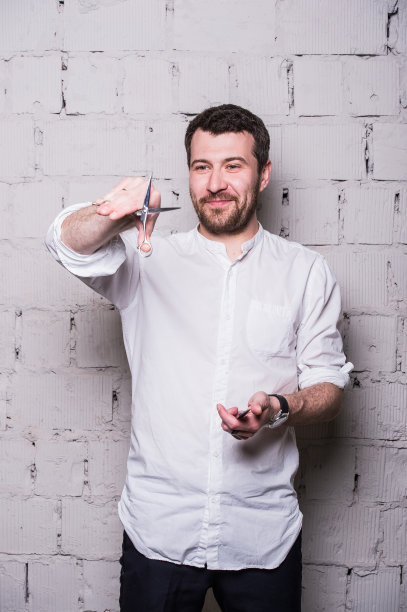 年轻漂亮的发型师穿着白衬衫图片下载