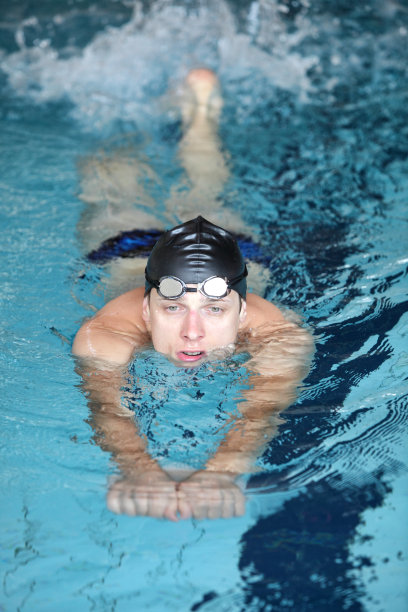 男子在室内游泳池练习踢腿。图片下载