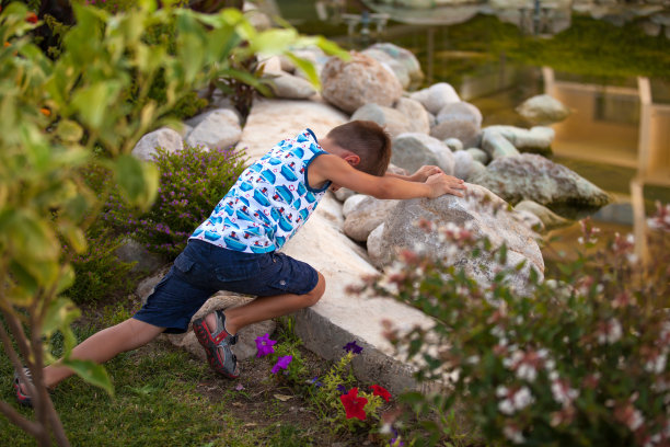 男孩正试图移动这块石头图片下载
