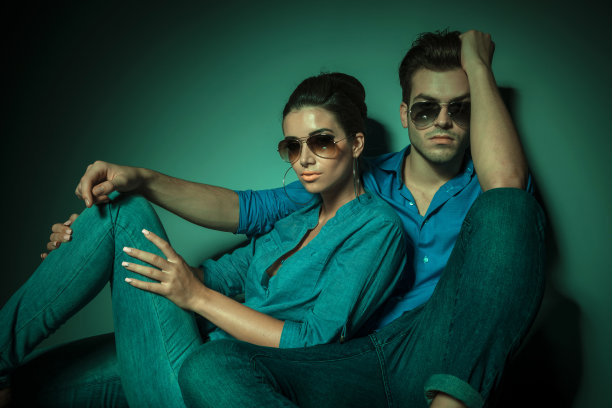 一对时尚夫妇坐在工作室背景上图片下载