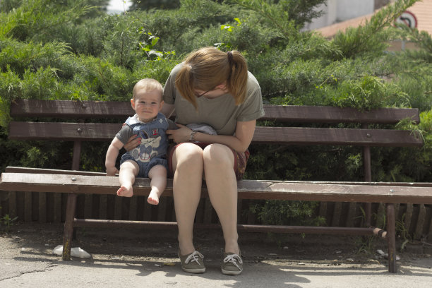 妈妈和小男孩坐在长凳上图片下载