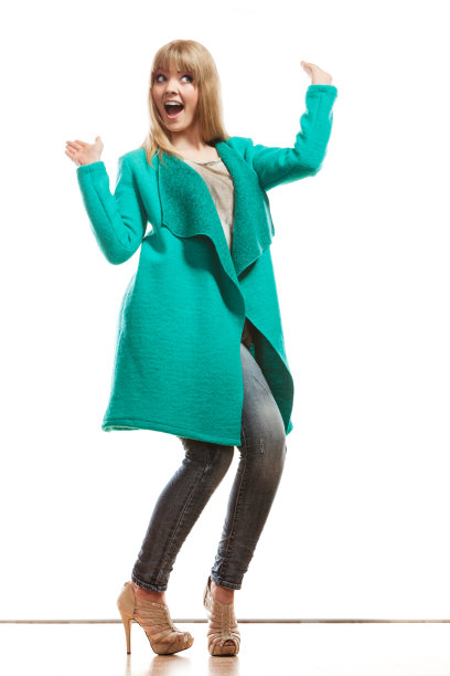 穿着绿色外套的长裙时尚女士。图片下载