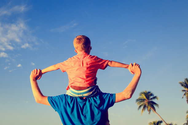 快乐的爸爸和小儿子在沙滩上玩耍素材图片