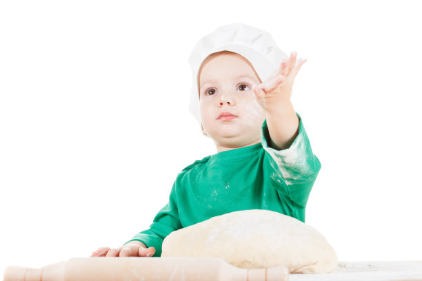 严肃的小男孩揉面团做饼干，在白色的图片下载