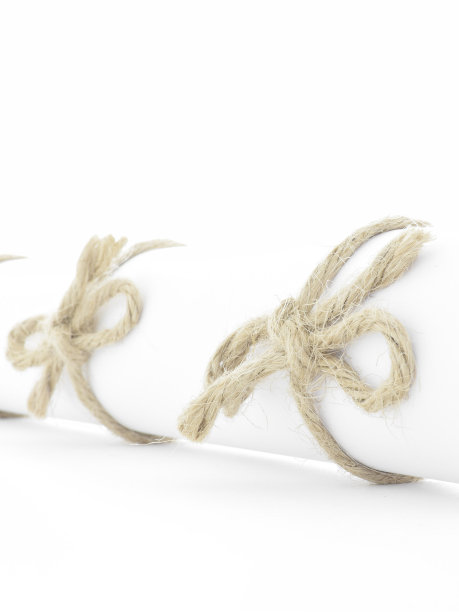 手工绳结系在白色字母卷轴孤立图片下载