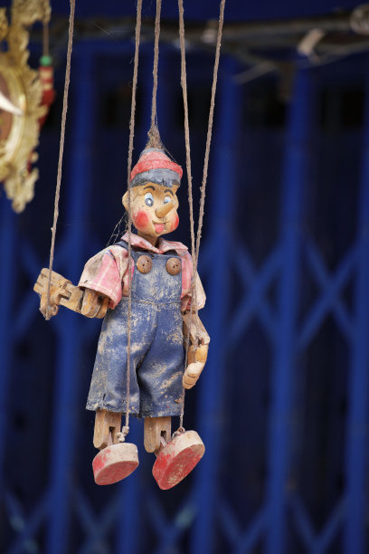 木娃娃挂在蓝色的背景图片下载