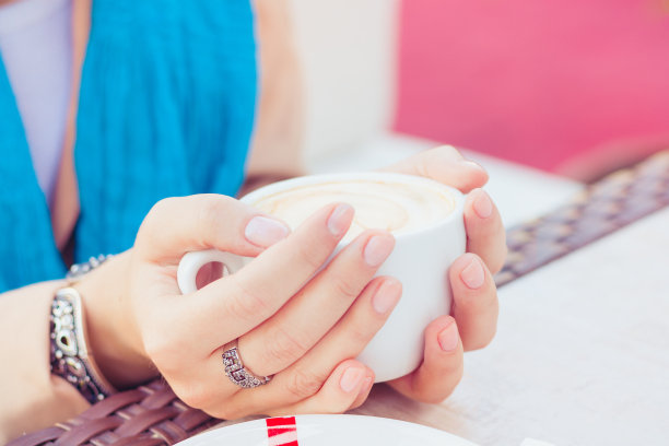 女人手里拿着一杯卡布奇诺图片下载