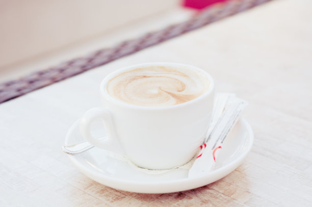 桌上放着一杯卡布奇诺图片下载