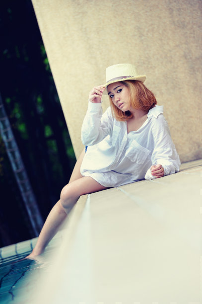 亚洲美丽的年轻性感女子摆姿势在游泳池图片下载